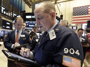 Trader Michael Urkonis, foreground, works on the floor of the New York Stock Exchange, Tuesday, May 24, 2016. Stocks are opening solidly higher on Wall Street, led by gains in technology stocks and banks.