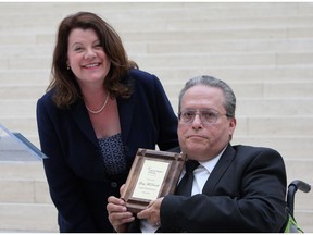 MLA Lori Sigurdson presents Gary McDonald with a plaque celebrating him as the longest residing tenant of the Capital Region Housing Corp. at the launch of their 2015 annual report at Edmonton City Hall on Monday, May 30, 2016. McDonald, who has lived in a CRHC unit for 45 years, says he knows just how lucky he has been to have found stable housing that can accommodate his mobility needs, as nearly 4,500 families are waiting for units to open.