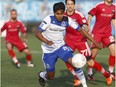 Edmonton's Shamit Shome, a graduate of the FC Edmonton youth academy, rushes with the ball through Fury defenders during a NASL game between FC Edmonton and the Ottawa Fury at Clarke Stadium in Edmonton on May 11, 2016.