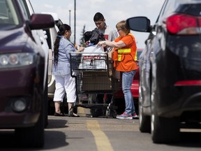 Wildfire evacuees pick up items from the Edmonton Emergency Relief Services Society sonation distribution centre at Kingsway Mall, in Edmonton Alta. on Tuesday May 17, 2016.
