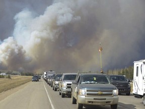 Smoke fills the air as people drive on a road in Fort McMurray, Alberta on Tuesday May 3, 2016.