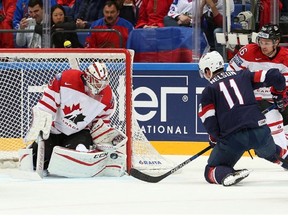 Cam Talbot of Canada fends off USA's Brock Nelson shot from the doorstep.