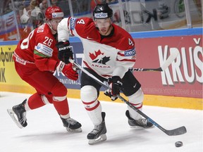 Canada's Taylor Hall, right, fights for the puck with Nikita Ustinenko of Belarus during the Hockey World Championships Group B match in St.Petersburg, Russia, May 9, 2016.