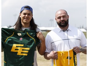 Fort McMurray Monarchs linebacker James Poitras, left, and team president Jesse Maddox hold donated Edmonton Eskimos uniforms near Foote Field in Edmonton, Alta., on Thursday, May 19, 2016. The Monarchs received uniforms and equipment from CFL teams and are fundraising to begin their season after having to evacuate because of the Fort McMurray fires.