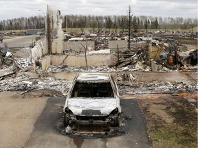 A charred vehicle and home are pictured in the Beacon Hill neighbourhood of Fort McMurray, Alberta, Canada, May 9, 2016.