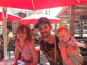 Lawrence Cooper with his children, Tegan Rae, two, and Dax, eight months, on the patio at Earls in downtown Edmonton Wednesday. Cooper is a chef at Earls in Fort McMurray who fled the city with his wife, Katie Maher, and their three children, including five-year-old Austin.