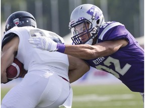 Western Mustang defensive back Josh Woodman tackles Toronto Varsity Blues wide receiver Michael Kanopoulos during their game TD Stadium in London, Ontario on Saturday, September 20, 2014. (File)