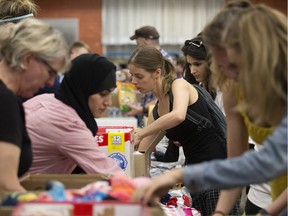 Volunteers sort donations for Fort McMurray wildfire evacuees at the Edmonton Emergency Relief Services May 4.
