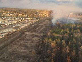 A fire break created by emergency crews is visible at left. Undated Fort McMurray wildfire photos.