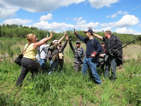 EALT volunteers high five after a day of Weeding for Wildlife at Glory Hills.