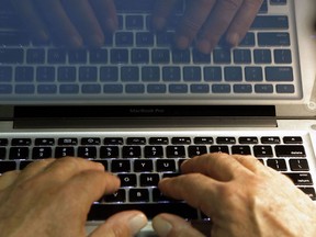 In this Feb. 27, 2013, file photo illustration, hands type on a computer keyboard in Los Angeles.