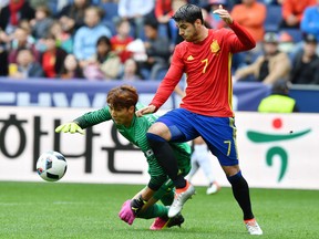 Spain's  Alvaro Morata left, challenge for the ball with South Korea's goalie  Kim Jin-Hyeon  during a friendly soccer match between Spain and South Korea in Salzburg, Austria, Wednesday, June 1, 2016. The Spain National Football Team is in Austria for a training camp in preparation for the  EURO 2016 soccer championships, hosted by France.