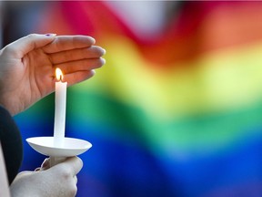 A candle burns in front of a pride flag while community members gather for a vigil  to honor the victims of the attack on a nightclub in Orlando, Fla. on Sunday, June 12, 2016,  at Friendship Square in Moscow, Idaho.