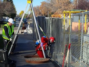 A City of Edmonton drainage employee enters the sewer system in West Jasper Place Oct. 8, 2015.