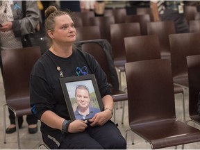 Michelle Duncan sits with a photo of her husband Jeff, a corrections officer who suffered from PTSD and took his own life as a result. Alberta marked the inaugural Post-Traumatic Stress Disorder Awareness Day at the Alberta Legislature on June 27, 2016. Photo by Shaughn Butts / Postmedia