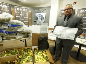 Staff Sgt. Pierre Blais displays a drug shipment from B.C. containing 60 kilograms of marijuana, drug manufacturing equipment and 2,000 fentanyl pills on Tuesday June 14, 2016.