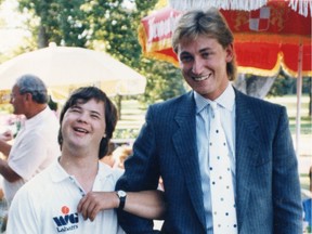 Joey Moss, the Edmonton Oilers locker room attendant, locks arms with Wayne Gretzky at a community event in August 1986.