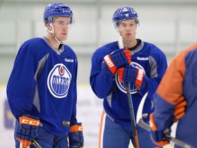 Edmonton Oilers Connor McDavid, left, and Taylor Hall talk with head coach Todd McLellan during training camp in Leduc, Alta., on Friday, Sept. 18, 2015.