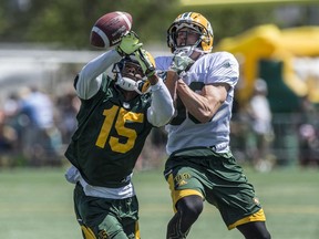 Defensive back Deion Belue tips the ball away from receiver Chris Getzlaf during Edmonton Eskimos practice at Clarke Park.