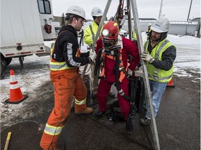 City worker Dayna Knapton comes out of a sewer line after doing an inspection in Edmonton on Wednesday Dec. 16, 2015.
