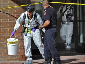 Members of the hazmat team exit the Canadian Blood Services building after a suspicious package was discovered in August 2014.