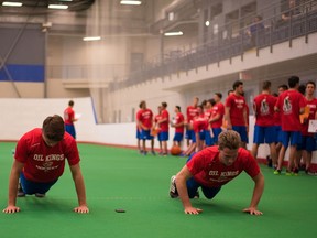 Jayden Platz and Ethan Cap do pushups during the Edmonton Oil Kings rookie fitness testing session at the Dow Centennial Centre in Fort Saskatchewan, Alta., on August 27, 2015.