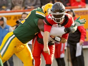 Edmonton Eskimos Cedric McKinley slams Calgary Stampeders quarterback Drew Tate during CFL action at McMahon Stadium in Calgary, Alta.. on Saturday June 11, 2016. Mike Drew/Postmedia