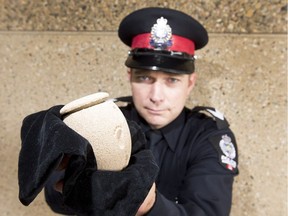 Sgt. Steve Sharpe holds up the lost urn that has since been returned to the Edmonton family that lost it.