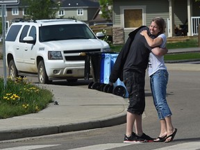 Neighbours Olivia Foran and Scott Heyduk, greet each other on day two of the phased re-entry on Walnut Cres., in the north end of the Timberlea area.