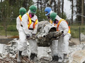 Team Rubicon members retrieve precious items including a motorcycyle owned by Quentin Thomas in the Stonecreek neighbourhood of Fort McMurray, Alta., on Wednesday June 8, 2016. Quentin died of cancer on May 6, and his nephew Kristen, brother Sheridan and friend Gary Reid wanted to get the bike to display in his memory. Photo by Ian Kucerak  Postmedia Wildfires Wildfire