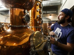 Head brewer Spike Baker checks his equipment as a cleanup crew works inside Wood Buffalo Brewing Company in Fort McMurray, Alta., on Thursday June 9, 2016.