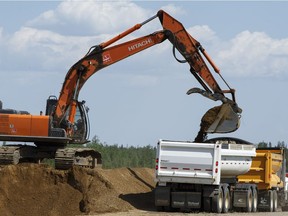 Construction crews work in the median of Highway 63 near Fort McMurray, Alta., on Tuesday June 7, 2016. The now twinned highway was the lifeline for people fleeing the massive wildfire.