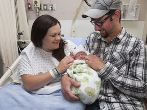 Melissa Taylor and Steven Mercer hold their son Eli Danny Roy Mercer, the first baby to be born in Fort McMurray since the wildfire evacuation May 3.