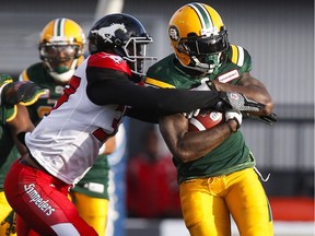 Edmonton Eskimos' Cedric McKinley, right, breaks a tackle by Calgary Stampeders' Maleki Harris during CFL pre-season football action in Calgary on June 11, 2016.