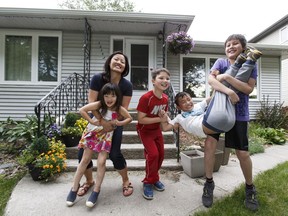 Angela Mao and her children, Ciella (left), 6, and Dominic (second from right), 9, with neighbours Victor (third from right), 8, and Ethan, 12, outside her bungalow in Forrest Heights in Edmonton on Tuesday, June 21, 2016.