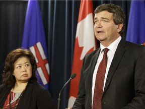 Alberta Agriculture Minister Oneil Carlier, right, with Agriculture Financial Services Corporation interim chairperson Bev Yee, isn't optimistic rules can be changed to help farmers whose crops from last year are still in the field.