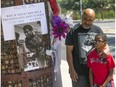 Lynn Boyd Jr. and his son Jayden look at an impromptu memorial for Muhammad Ali outside the Osborn Medical Center, Saturday, June 4, 2016, in Scottsdale, Ariz. Ali died Friday at the age of 74.