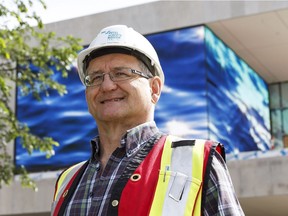 Tom Thurston, director of capital development with the Royal Alberta Museum posesin front of new video screens being tested at the museum's construction site.