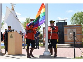 RCMP deputy commissioner Marianne Ryan raises the Pride flag at Alberta RCMP Headquarters in Edmonton on June 2, 2016.