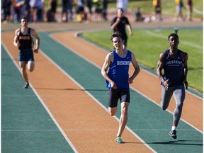 Ryder Horton, in blue, takes first place during the men's 400 metre dash junior event during the 2016 ASAA Track and Field Championships at Foote Field in Edmonton, Alta., on Saturday, June 4, 2016.