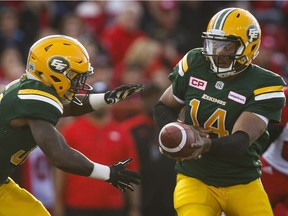 Edmonton Eskimos' quarterback James Franklin hands the ball off to Shakir Bell during first half CFL pre-season football action against the Calgary Stampeders in Calgary, Saturday, June 11, 2016.THE CANADIAN PRESS/Jeff McIntosh ORG XMIT: JMC102