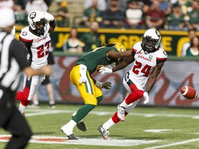 Edmonton's Derel Walker (centre) is blocked by Ottawa's Forrest Hightower (23) and Jerell Gavins (24) during a CFL game between the Edmonton Eskimos and the Ottawa Redblacks at the Brick Field at Commonwealth Stadium in Edmonton on  June 25, 2016.