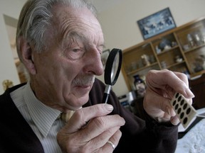 Charles Stelckl in 2005 examines slides from field work which took place at Loon River in 1951. 
Thursday, September 22,  2005. (Kelly Taylor/Edmonton Journal)