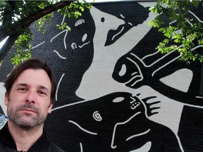 L.A. painter Cleon Peterson stands in front of a section of his 80-foot, untitled mural on the side of El Cortez, 8230 Gateway Blvd. across from Old Strathcona Farmer's Market.