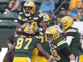 Edmonton Eskimos John White (top) and Derel Walker celebrate a touchdown against the Ottawa Redblacks during first half CFL action in Edmonton, Alta., on Saturday, June 25, 2016.