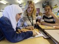 File - Teacher Leandra Jack (centre) watches as Batoul Hamsho, 13, (left) and Wanas Asnki, 12, play a math game in her Grade 5/6 split class at Evansdale School in Edmonton on June 23, 2016.