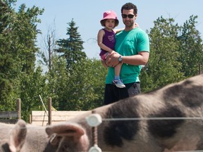 Participants Devon and Adalyn Award contemplate the pig pen during in the Taste Alberta farm tour in 2014.