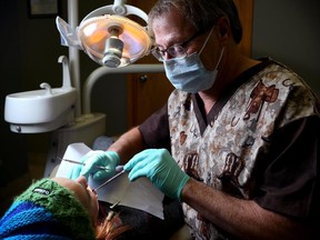 A dentist works on a patient at the Hanna Dental Clinic in Hanna, Alta., in this file photo.