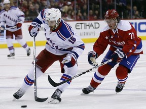 New York Rangers center Derick Brassard (16) skates with the puck as Washington Capitals right wing T.J. Oshie (77) behind, in the second period of an NHL hockey game, Sunday, Jan. 17, 2016, in Washington. (AP Photo/Alex Brandon)