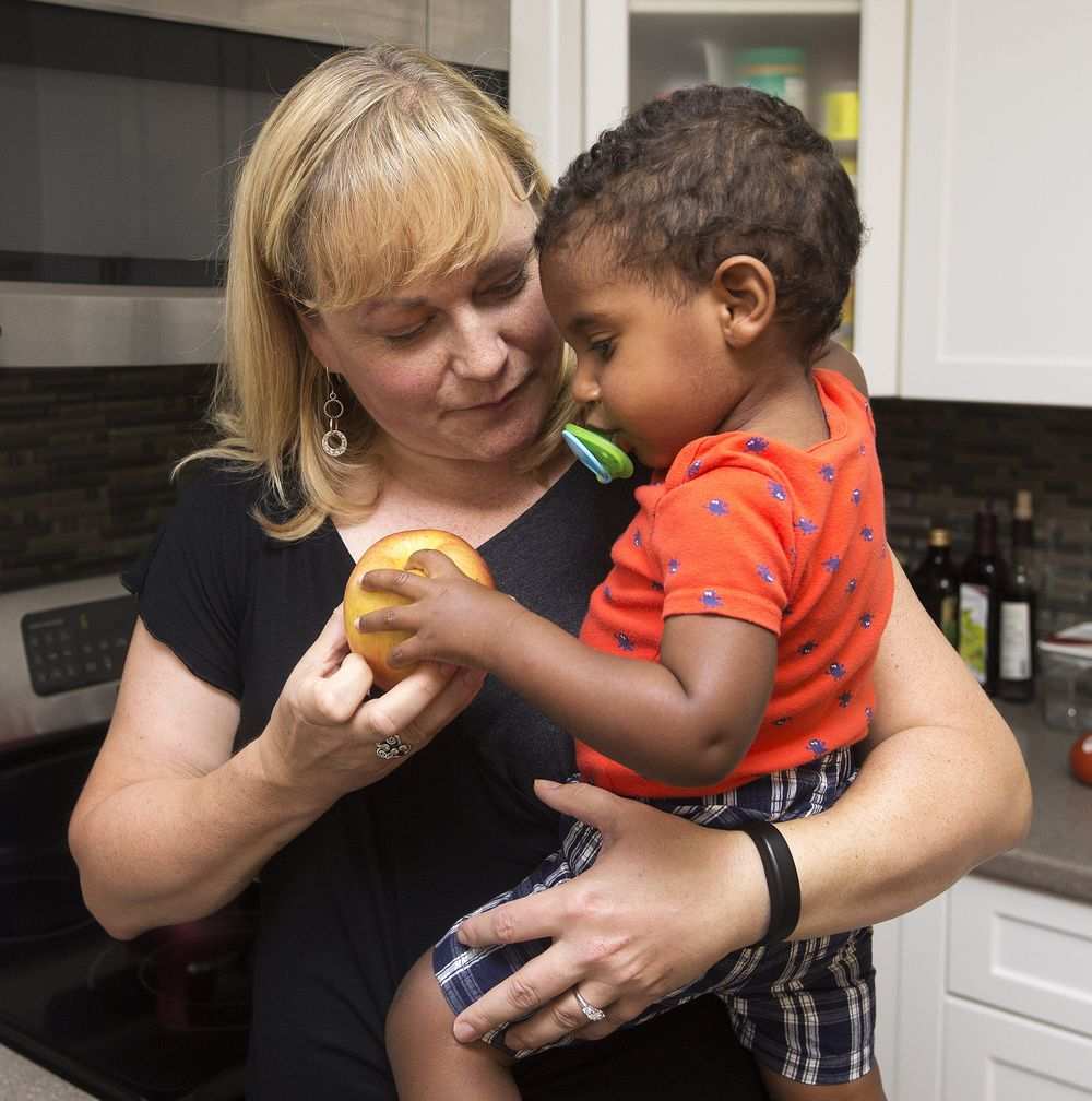 Joanne Currie her adopted son Jacob Currie, 19 months old, get a snack at their home in Sherwood Park on June 27, 2016.